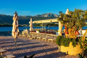 a group of chairs and umbrellas on a beach at Apart-hotel Villa Lav in Tivat