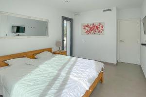 a bedroom with a large white bed in it at Casa Limon Ferienhaus bis 6 Gäste in Cala Pi mit Meerblick und privatem Pool in Niederdorla