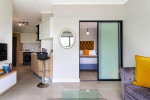a living room with a couch and a kitchen at AlimamaSpaces The Chelsea's Munyaka in Midrand