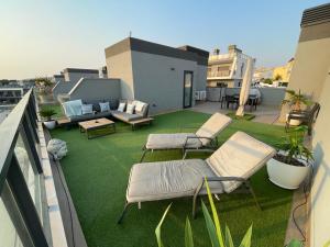 a balcony with chairs and a patio with green grass at Iconic Alluba Alicante luxury bay in Gran Alacant