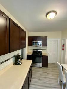 a kitchen with wooden cabinets and a stove top oven at Tropical Oasis - Room 3 in Irvington