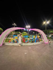 a woman standing in front of a playground at night at Central Apartment - Plaza de Armas, Rioja in Rioja