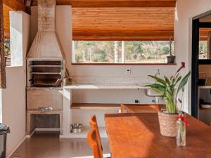 una cocina con una mesa y una estufa en Casa Tempo | 2h30 SP | Exclusividade na montanha, en Santo Antônio do Pinhal 106 fotos más