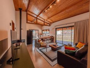 una sala de estar con un sofá y una mesa en Casa Tempo | 2h30 SP | Exclusividade na montanha, en Santo Antônio do Pinhal