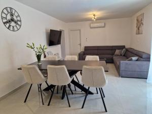 a living room with a dining room table and chairs at Apartman Mista in Solin