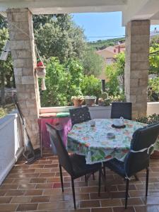 a patio with a table and chairs on a patio at Vera Apartment in Rab