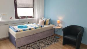 a small bedroom with a bed and a chair at Die ideale Wohnung für 2 Personen in Solingen