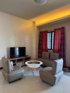 a living room with a couch and a table and chairs at C7 Hotel with beach front access in Iloilo City