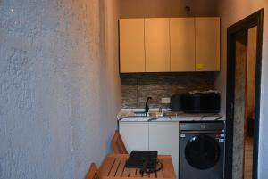 une cuisine avec un lave-linge et un micro-ondes dans l'établissement Muro's Guesthouse, à Mestia
