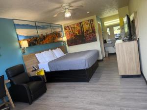 a hotel room with a bed and a chair at Deerfield Inn in Parsons