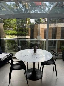 バルエリにあるAlpha Luxury Gardenの大きな窓のある部屋にあるテーブルと椅子 +34枚の写真