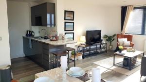 a living room with a kitchen and a living room with a couch at Beach Haven - FREE PARKING - Luxury 2 bedroom 2 bathroom Town Centre Apartment by Coastline Retreats in Bournemouth