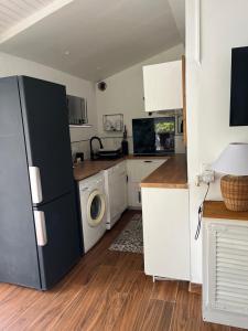 a kitchen with a refrigerator and a washer and dryer at L'Enclos in Sérignan-du-Comtat