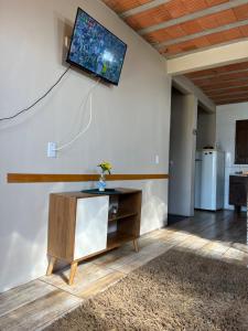 a living room with a tv hanging on a wall at Ótima casa de praia a 2 quadras do mar in Tramandaí