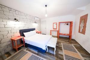 a bedroom with a white bed and a brick wall at VoQ Alaçatı Hotel in Çeşme