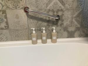 a group of three shampoo bottles sitting on top of a bath tub at Ferienwohnung am Kinzigberg 5 in Schlüchtern