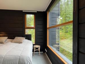 a bedroom with a bed and a large window at Villa Ruka - Rising Sun with 3 bedrooms, loft, sauna and balcony with a view in Ruka