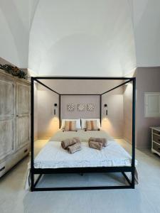 a bedroom with a large bed with a black frame at Relais Filomarino casa vacanze in Corsano +22 photos