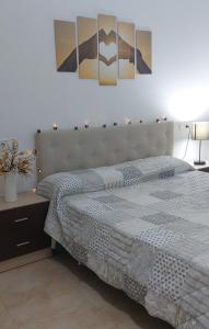 a bedroom with a large bed and two pictures on the wall at CALA HOUSE I Espacioso apartamento céntrico, aire acondicionado y parking incluido in Peñíscola