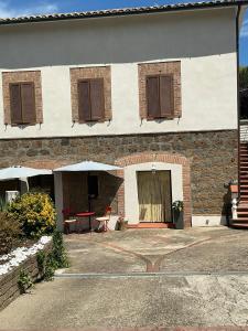 a building with brown shuttered windows and a table at Cottage Apanu in Viterbo