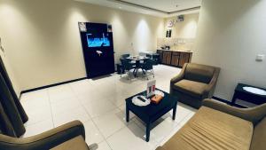 a living room with a couch and chairs and a table at شقق دار الفرسان المخدومة in Quai
