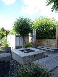 un jardin avec une cuve en béton contenant un arbre dans l'établissement Ferienwohnung mit Entspannungserlebnis im Garten mit Terrasse, à Wildpoldsried