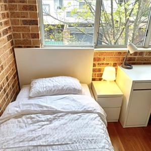 een kleine slaapkamer met een bed en een raam bij FlexiRoom on Hereford in Sydney