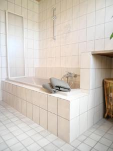 - une salle de bains blanche pourvue d'une baignoire et d'une serviette dans l'établissement Ferienwohnung mit Entspannungserlebnis im Garten mit Terrasse, à Wildpoldsried