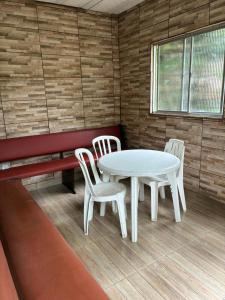 a room with a table and chairs and a bench at Teresópolis Hostel in Teresópolis