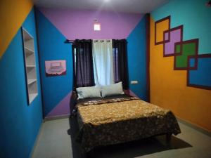 Un dormitorio con una cama con una pared colorida. en The Iris homestay, en Madikeri