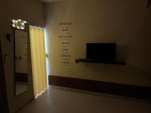 a room with a television and writing on the wall at Mini Departmento in Jiutepec