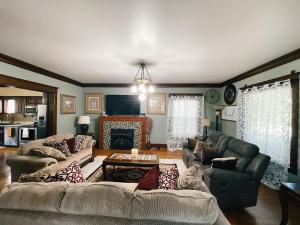 a living room with a couch and a fireplace at Victorian Home in Original Grandeur Downtown in Kokomo