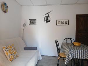 a white room with a table and a couch and a table and chair at Le Som' des Pyrénées in Luz-Saint-Sauveur