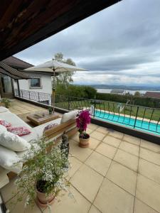 a patio with a view of a swimming pool at Alps and Lakeview Villa with Pool in Haut-Vully