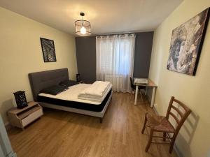 Un dormitorio con una cama, una mesa y una silla. en T4 proche de Neyrpic, en Saint-Martin-dʼHères