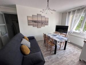 Una sala de estar con un sofá, una mesa y un televisor. en T4 proche de Neyrpic, en Saint-Martin-dʼHères