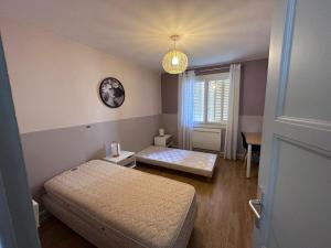 Un dormitorio pequeño con una cama y una ventana. en T4 proche de Neyrpic, en Saint-Martin-dʼHères
