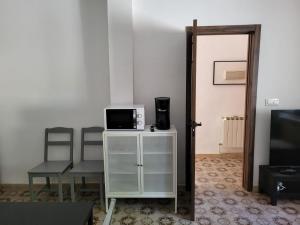a room with a tv and a cabinet with a microwave at El rincón de cauca in Coca