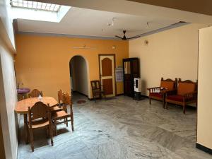 a room with a table and chairs and a couch at Thillai Natarajar Nivas - Family Stay in Chidambaram