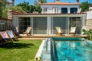 einen Hinterhof mit Pool und Stühlen und ein Haus in der Unterkunft Noesta Alaçatı in Alacati