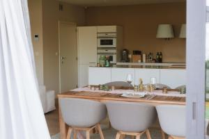 una cucina con un bancone con tavolo e sedie di La Petite Foret Contemporary Apartment In Halle a Halle