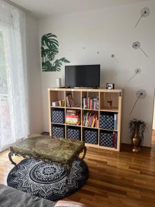 sala de estar con TV y estante de libros en Sunny City-Mountain-Lake Getaway, en Villach