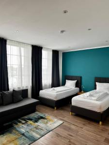 a hotel room with two beds and a couch at Ferienwohnung 302 am Kasinopark in Georgsmarienhütte