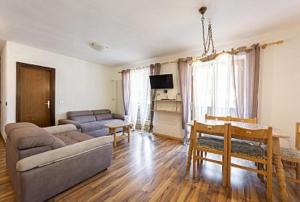 una sala de estar con un sofá y una mesa en Appartamenti Callori Karin, en Canazei