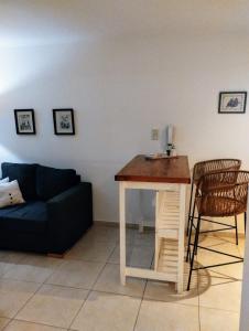 Una sala de estar con un sofá azul y una mesa. en Paloma Suites, en Tandil