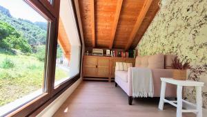 a room with a couch and a large window at Reguero Gato Turismo Rural in Candamo