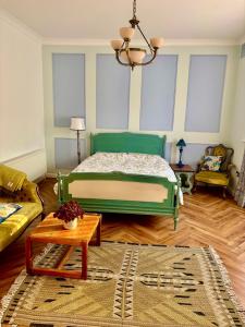 a bedroom with a bed and a couch and a table at Art Deco House Oceanview in Wicklow