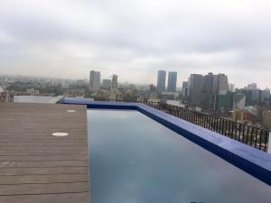 a swimming pool on the roof of a building at Cozy, Elegant & Comfortable Apartment in Lima in Lima