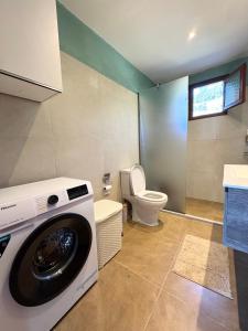 a washing machine in a bathroom with a toilet at Join In Home in Pogoniá