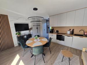 a kitchen and dining room with a table and chairs at Domek na Kaszubach nad jeziorem Kamień - Prywatne Jacuzzi i Rowerek Wodny in Kamień